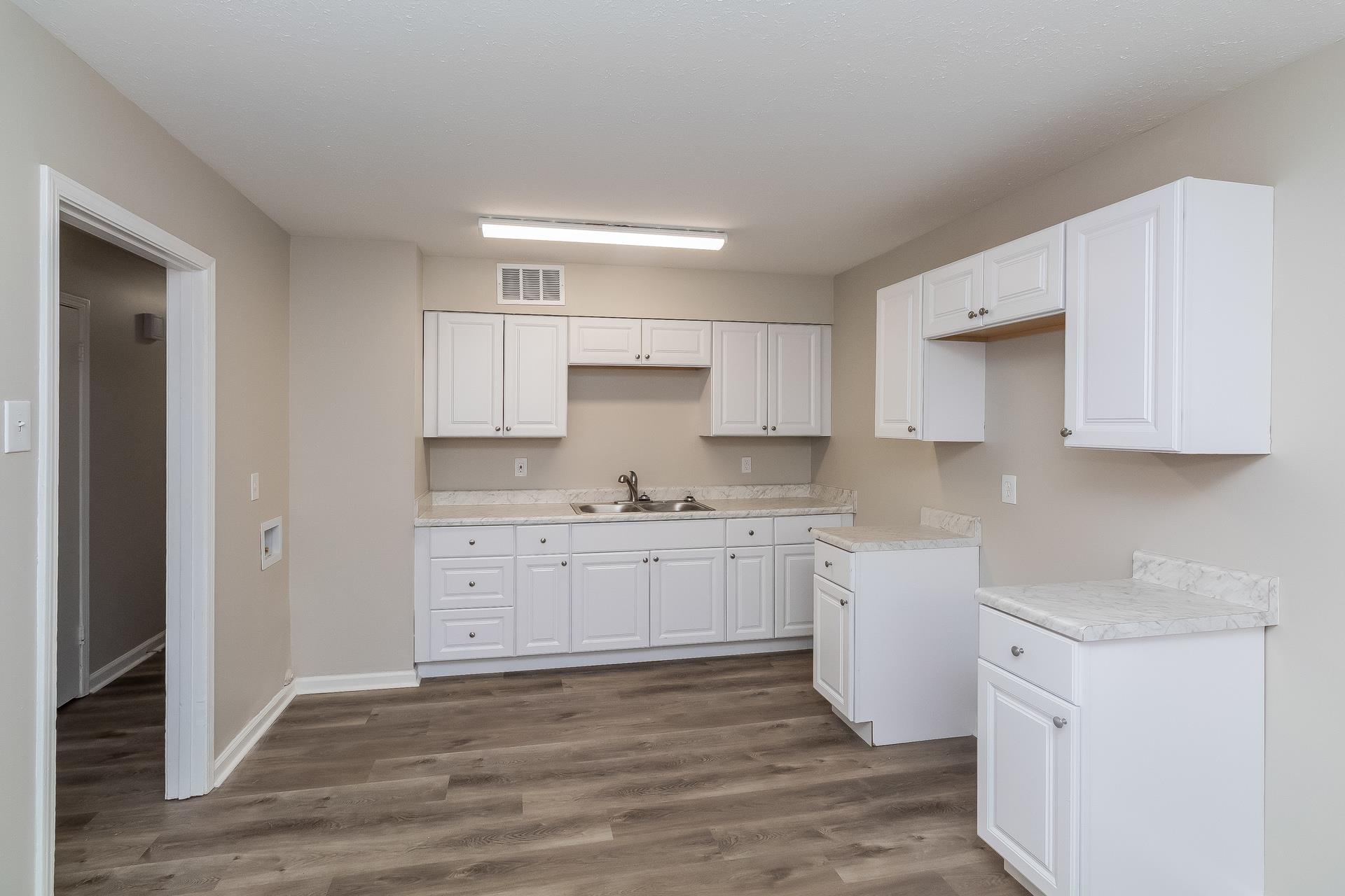 453 Charter Avenue Memphis, TN 38109 - Photo 3 of 16 a kitchen with granite countertop white cabinets white stainless steel appliances with a sink and dishwasher