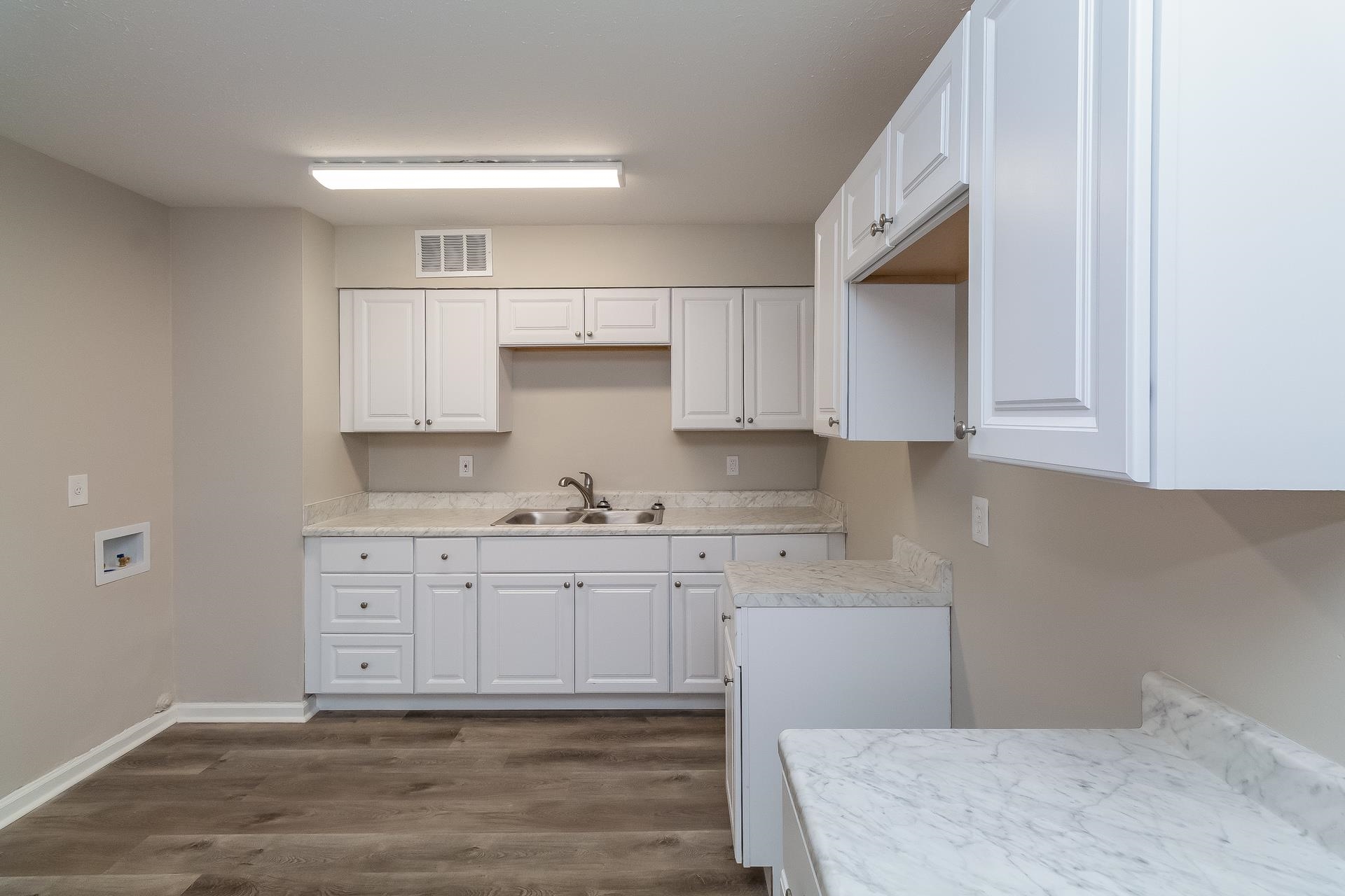 453 Charter Avenue Memphis, TN 38109 - Photo 4 of 16 a kitchen with granite countertop white cabinets and white appliances