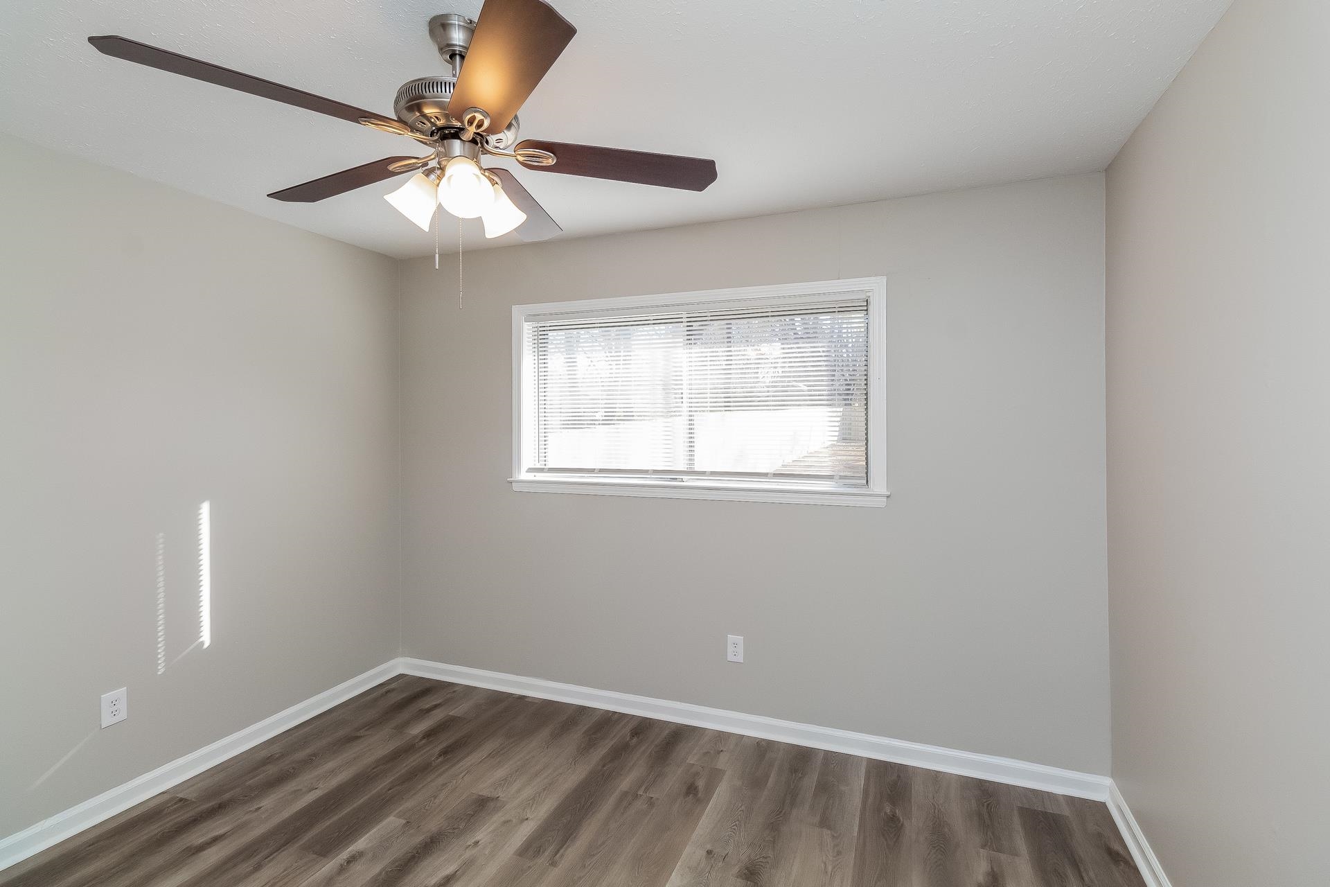 453 Charter Avenue Memphis, TN 38109 - Photo 6 of 16 an empty room with a window and a fan