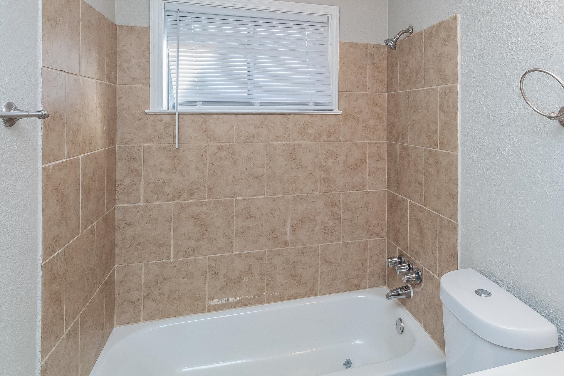453 Charter Avenue Memphis, TN 38109 - Photo 7 of 16 a bathroom with a bathtub and a shower