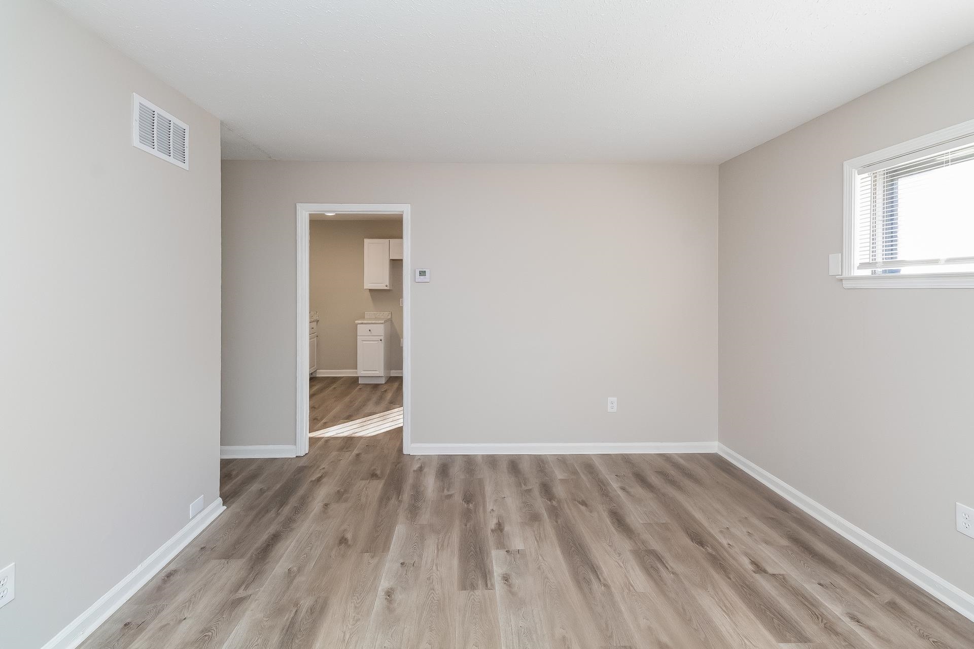 453 Charter Avenue Memphis, TN 38109 - Photo 9 of 16 a view of a room with wooden floor and a window