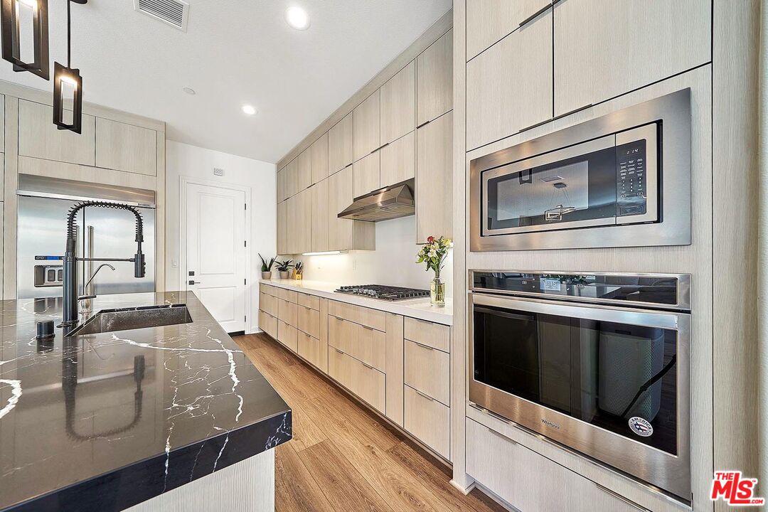 20641 Walnut Circle Porter Ranch, CA 91326 - Photo 16 of 47 a kitchen with stainless steel appliances granite countertop a stove microwave and sink