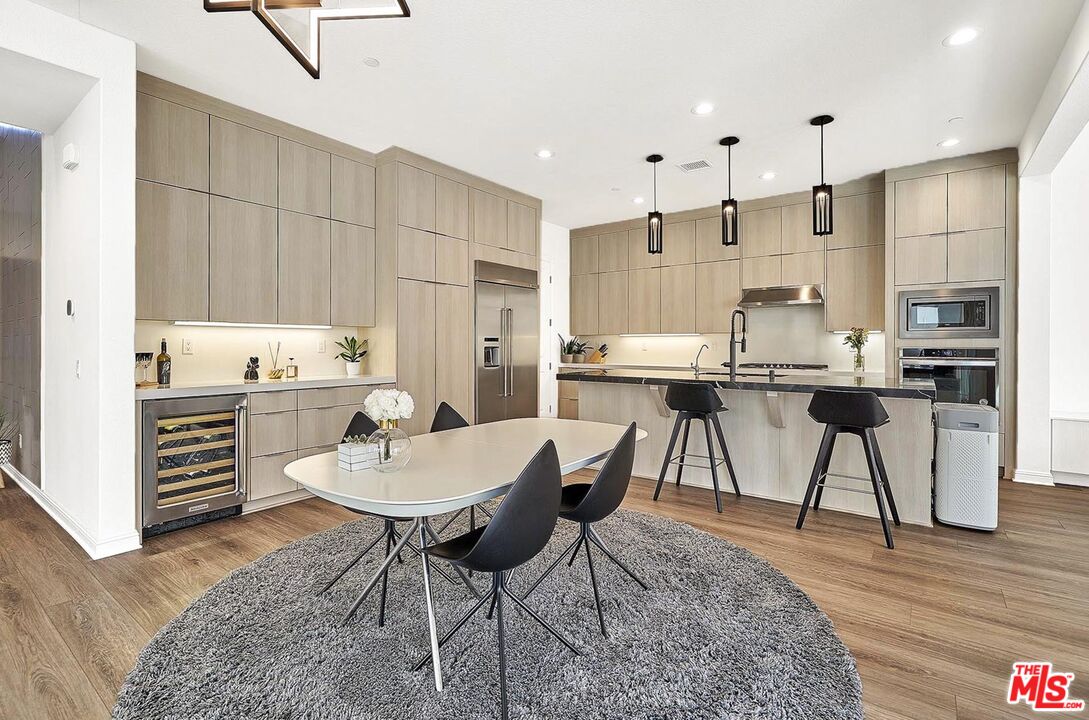 20641 Walnut Circle Porter Ranch, CA 91326 - Photo 9 of 47 a kitchen with kitchen island a stove a table and chairs in it