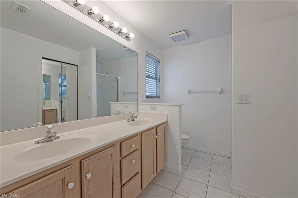 7001 Lone Oak Boulevard Naples, FL 34109 - Photo 15 of 25 a bathroom with a double vanity sink and a mirror