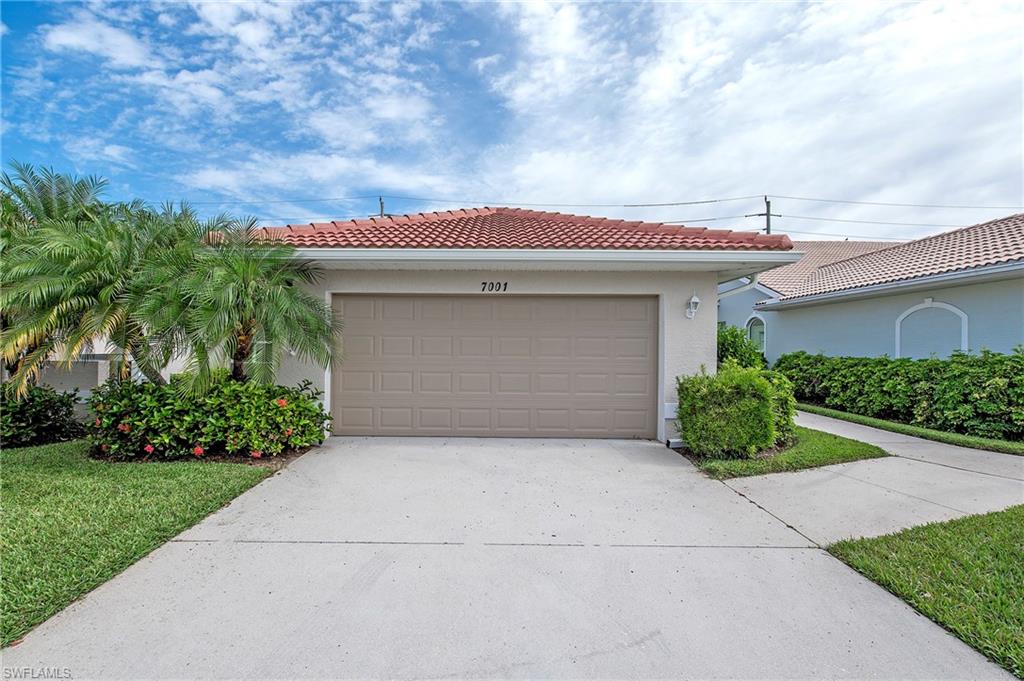 7001 Lone Oak Boulevard Naples, FL 34109 - Photo 2 of 25 a house view with a garden space