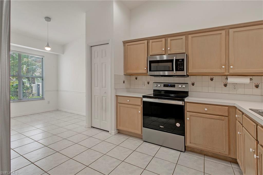 7001 Lone Oak Boulevard Naples, FL 34109 - Photo 9 of 25 a kitchen with a stove a microwave and a sink