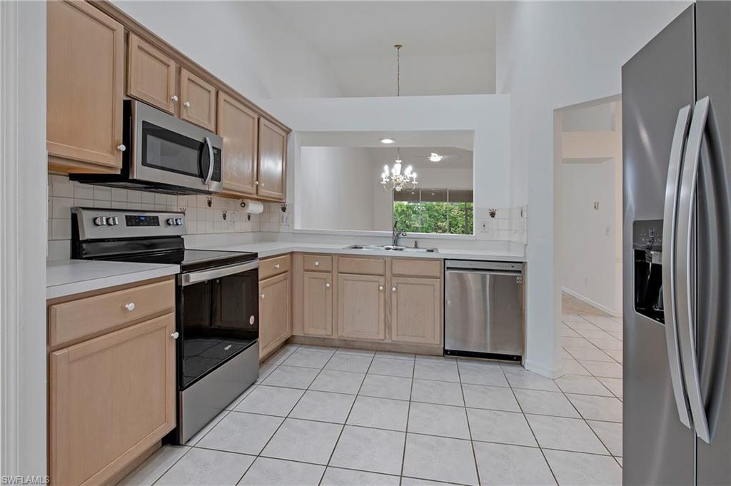 7001 Lone Oak Boulevard Naples, FL 34109 - Photo 10 of 25 a kitchen with a sink a stove and refrigerator