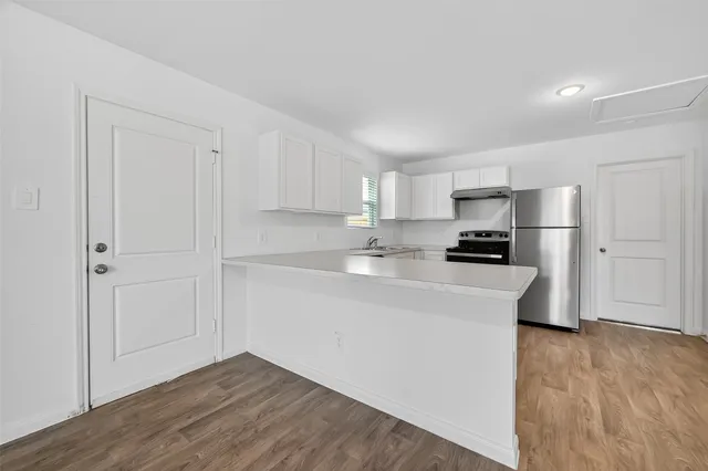 a kitchen with stainless steel appliances granite countertop a refrigerator sink and stove