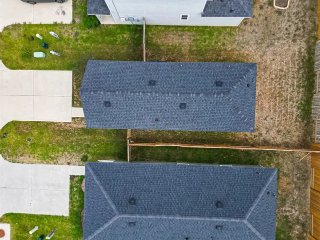 an aerial view of residential houses with yard