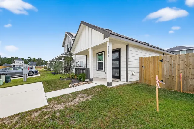a view of kitchen and empty room with wooden floor