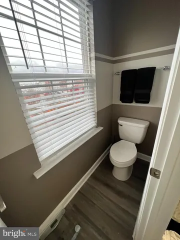 a bathroom with a toilet a sink and a window