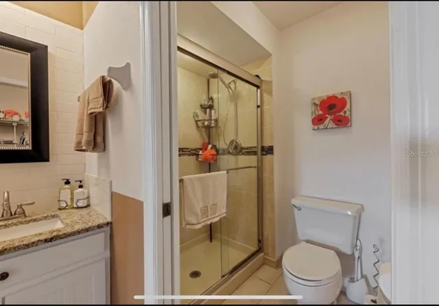 a bathroom with a granite countertop toilet sink and mirror