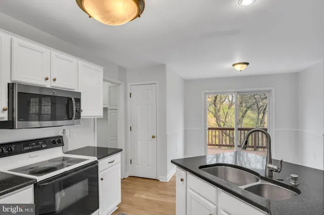 a kitchen with granite countertop a stove and a sink