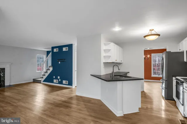 a view of empty room with wooden floor and fireplace