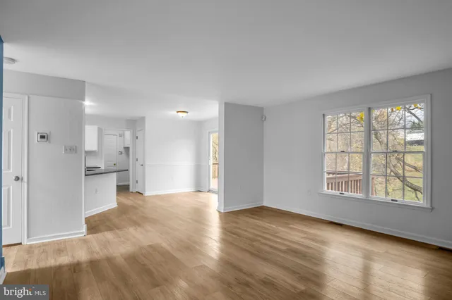 a view of a living room with kitchen view and wooden floor