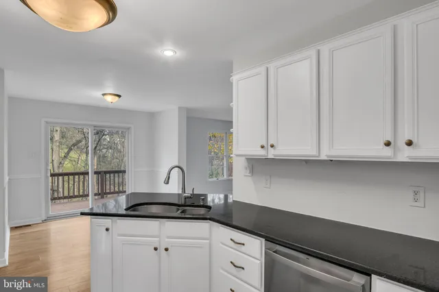 a kitchen with granite countertop a sink stainless steel appliances and cabinets