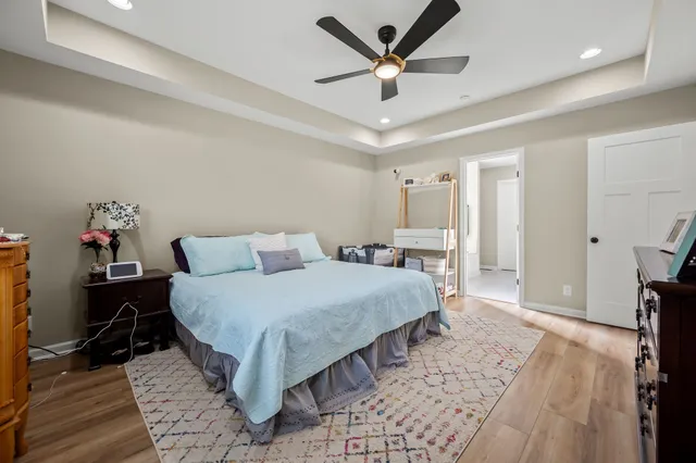 a spacious bedroom with a bed a ceiling fan and a rug