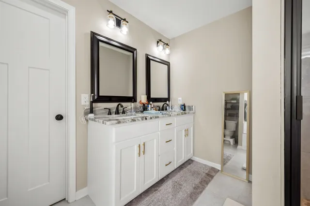 a bathroom with a double vanity sink and a mirror