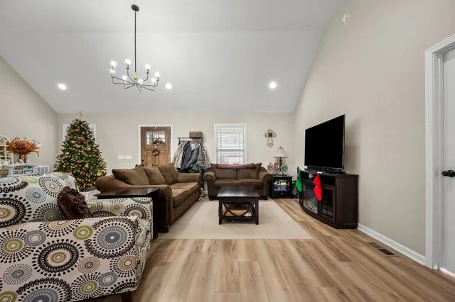 a living room with furniture a flat screen tv and a chandelier
