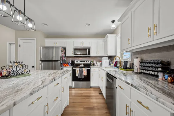 a kitchen with stainless steel appliances granite countertop a stove a sink dishwasher and a refrigerator