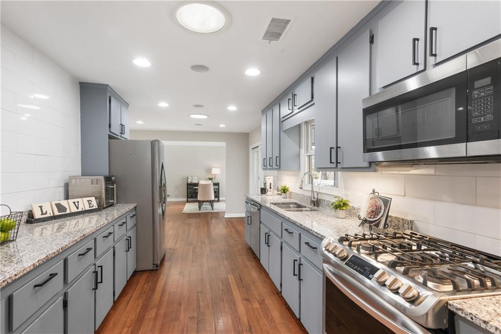413 Sassafras Road Roswell, GA 30076 - Photo 6 of 67 a kitchen with stainless steel appliances a stove top oven a sink dishwasher and cabinets with wooden floor