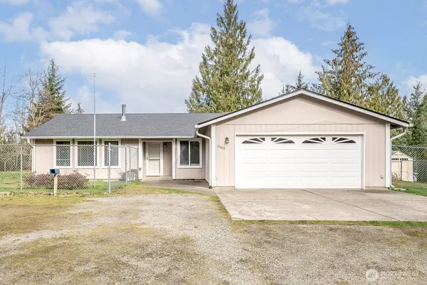 a view of a house with a yard and garage