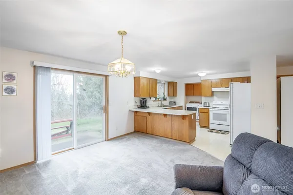 a open kitchen with kitchen island a large window cabinets and stainless steel appliances