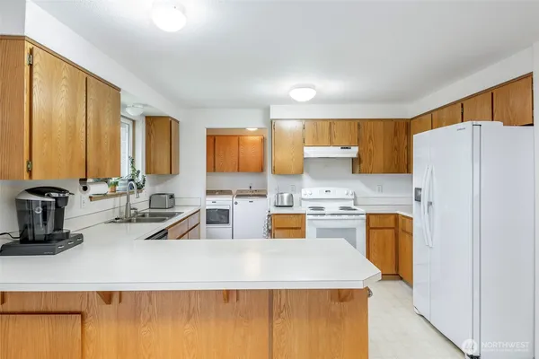 a kitchen with a refrigerator a stove and a sink