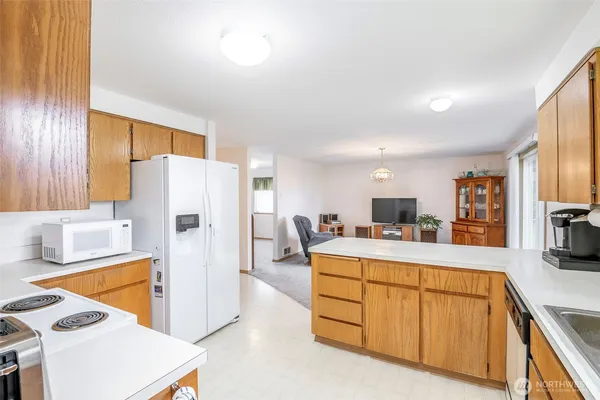 a large white kitchen with cabinets a sink and a refrigerator