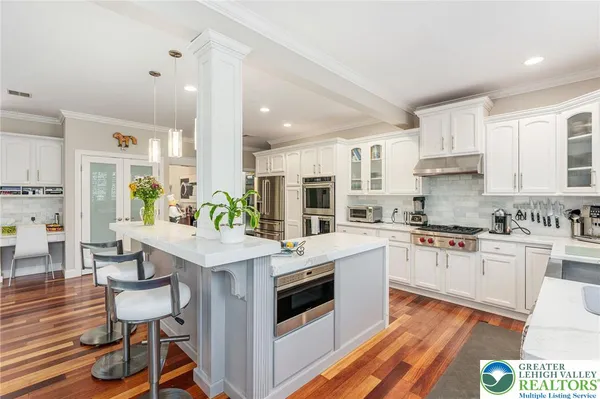 a kitchen with stainless steel appliances white cabinets a sink and a stove