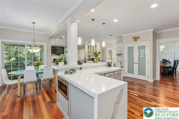 a view of a kitchen with kitchen island wooden floor center island and stainless steel appliances
