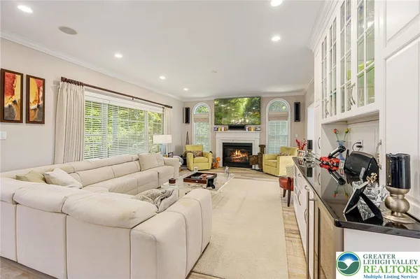 a living room with furniture a fireplace and a floor to ceiling window