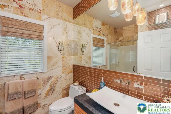 a bathroom with a sink a toilet and shower