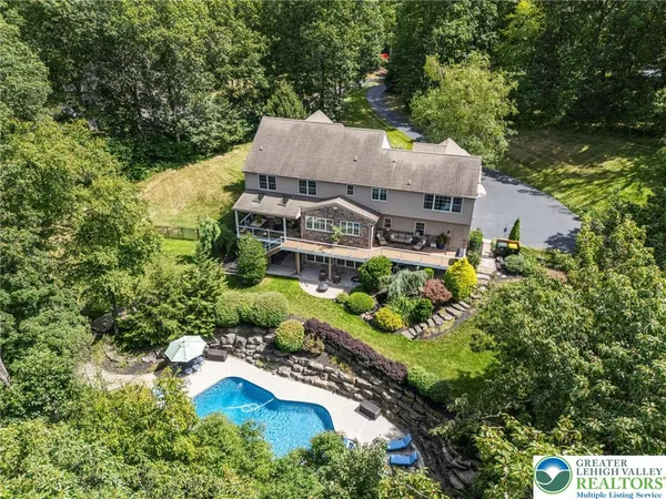 an aerial view of a house with a garden and lake view