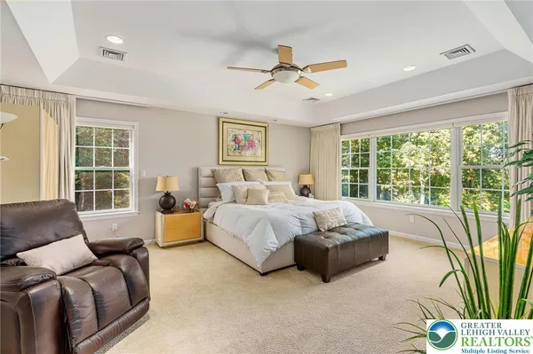 a spacious bedroom with a bed couch and a large window