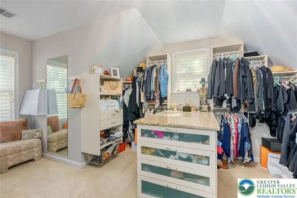 a view of walk in closet with clothes and shoes