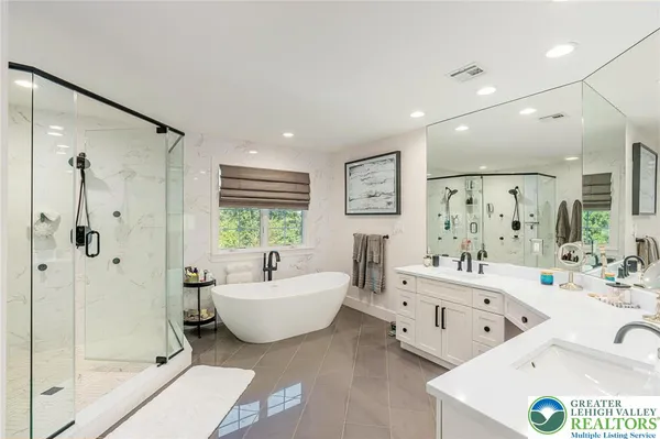 a spacious bathroom with a bathtub sink and mirror