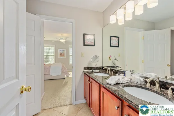 a en suite bathroom with a granite countertop sink a mirror and a