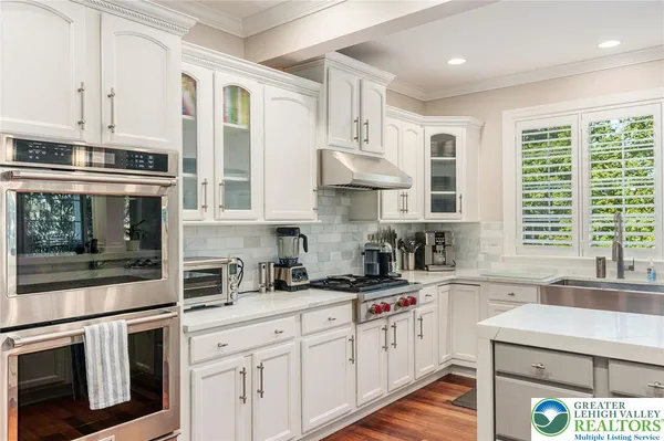 a kitchen with stainless steel appliances white cabinets and a window