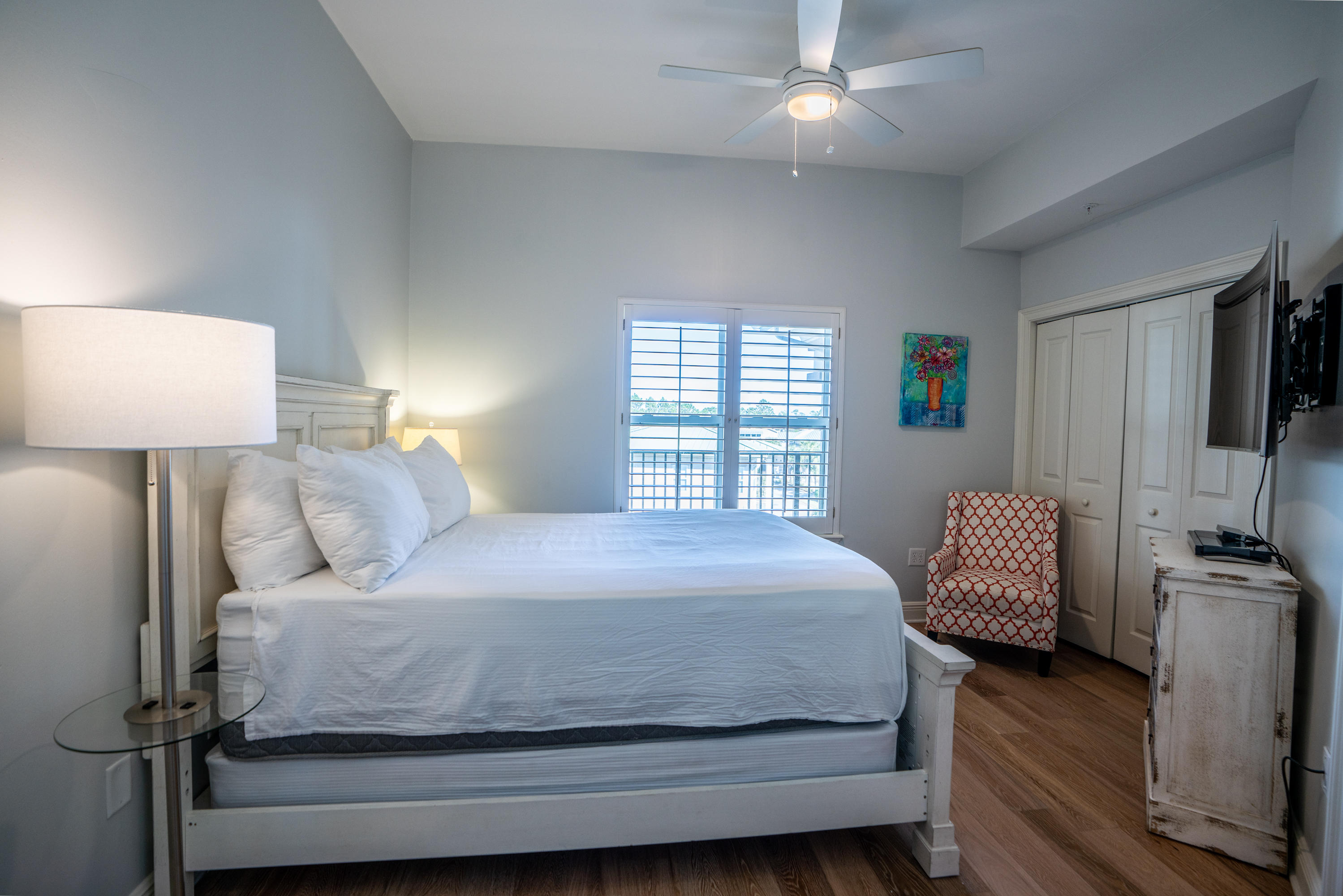 3880 East County Highway 30A, Unit 402 Santa Rosa Beach, FL 32459 - Photo 24 of 62 a bedroom with a bed wooden floor and a lamp
