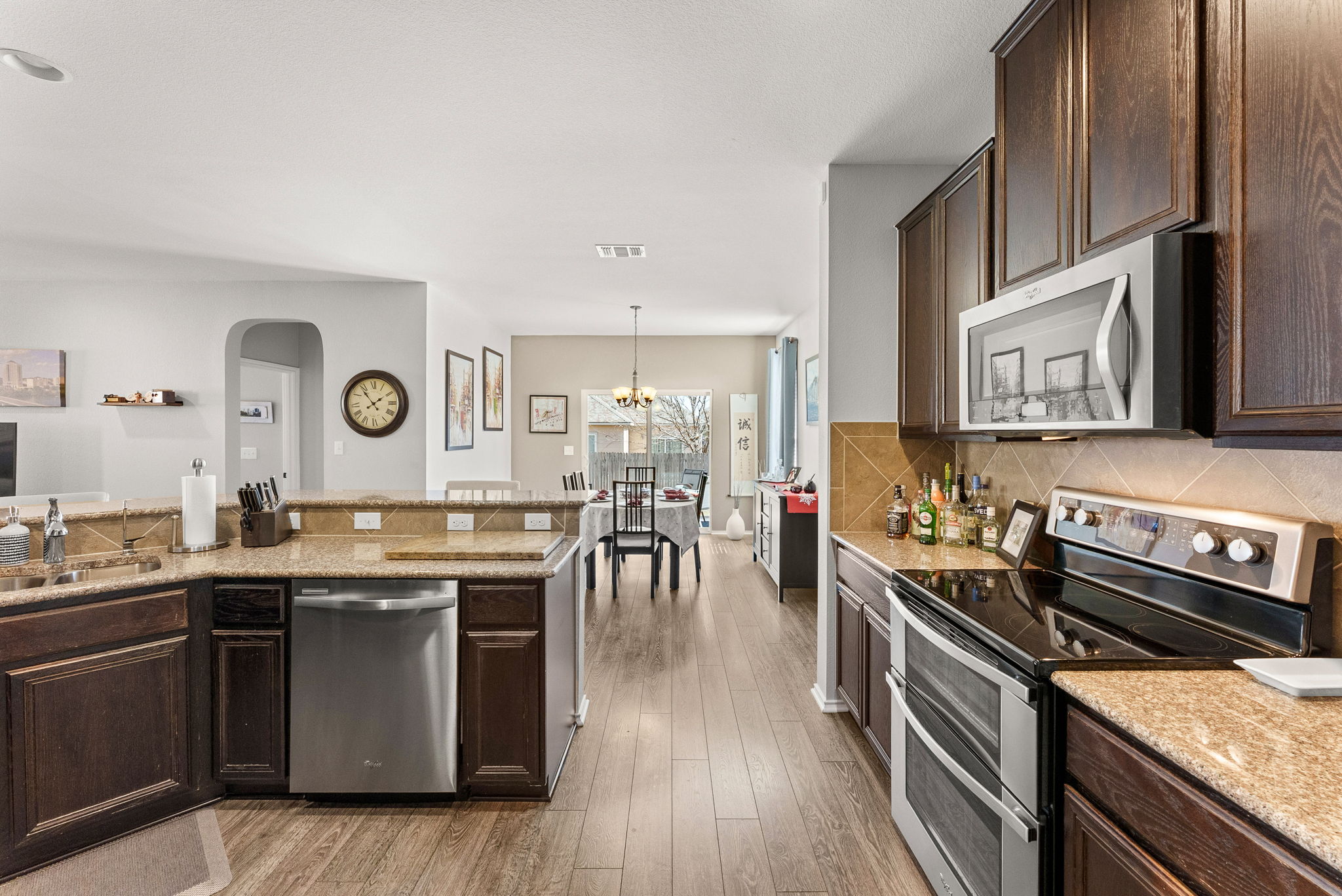 11209 Kildoon Drive Austin, TX 78754 - Photo 16 of 37 Kitchen with dark wood finish cabinets, stainless steel appliances, granite countertops