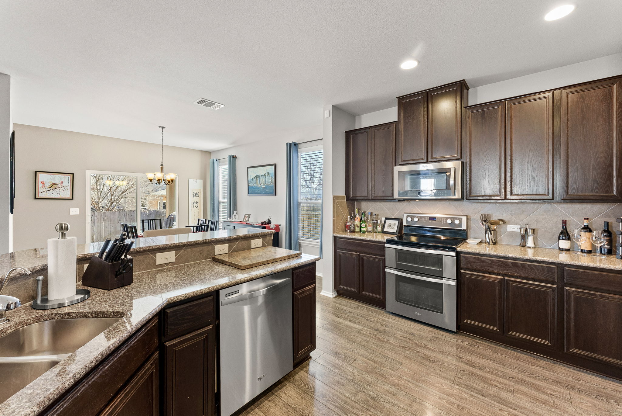 11209 Kildoon Drive Austin, TX 78754 - Photo 17 of 37 Kitchen with dark wood finish cabinets, stainless steel appliances, granite countertops