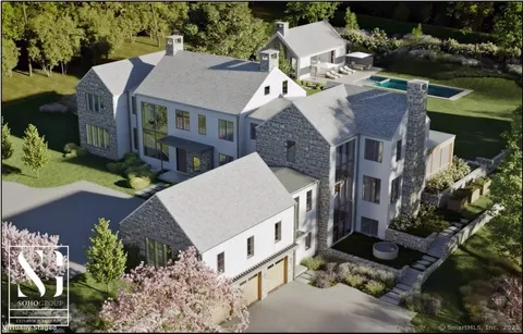an aerial view of a house with a garden and lake view
