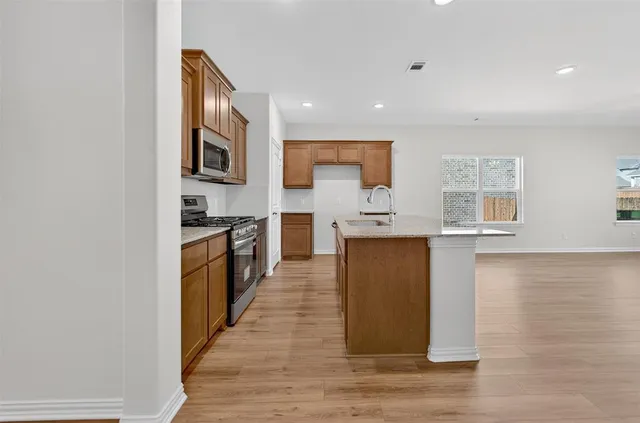 a kitchen with stainless steel appliances granite countertop a refrigerator and a stove top oven
