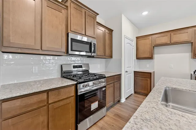 a kitchen with granite countertop cabinets stainless steel appliances and a counter space