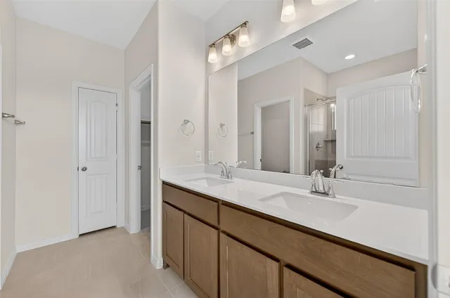 a bathroom with double vanity sinks and a mirror