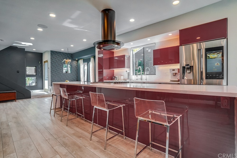1051 Prospect Avenue Long Beach, CA 90804 - Photo 12 of 56 a kitchen with stainless steel appliances kitchen island granite countertop a table chairs sink and wooden cabinets