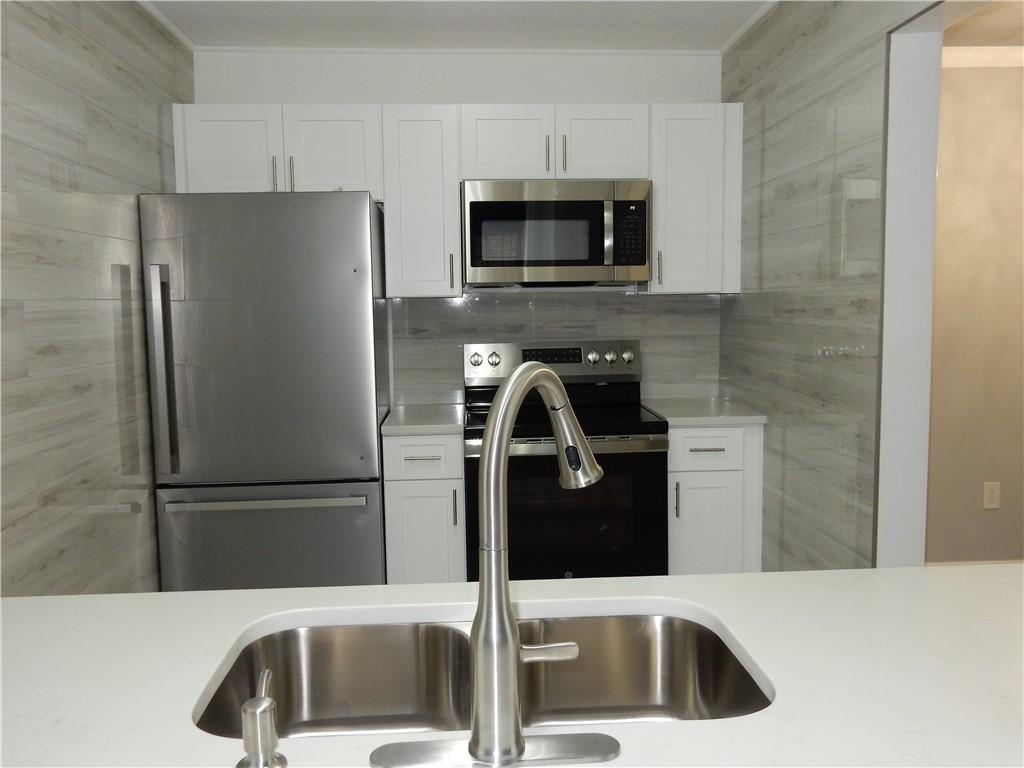 3083 Colonial Way, Unit N Atlanta, GA 30341 - Photo 5 of 20 a kitchen with a refrigerator and a sink