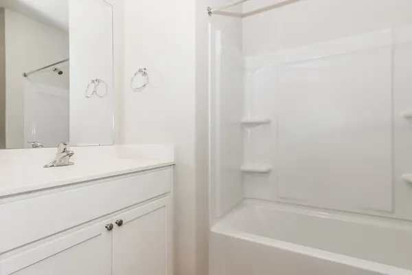 a bathroom with a bathtub sink vanity and mirror
