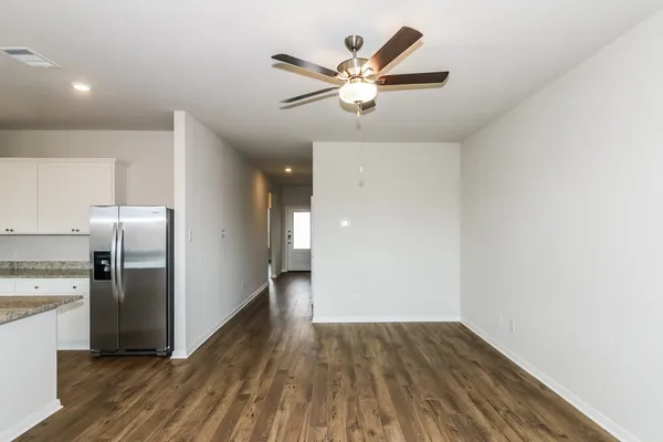 a view of a kitchen with wooden floor a sink and a refrigerator